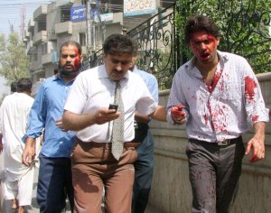 Injured men are seen near the site of the car bombing in Lahore, Pakistan on Wednesday, May 27, 2009. (AP / K.M. Chaudary)